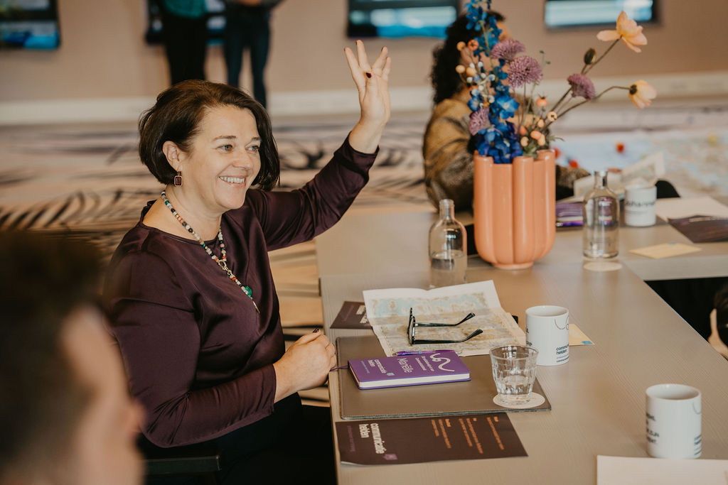 Deelnemers lachend aan het werk tijdens een training van Communicatiehelden